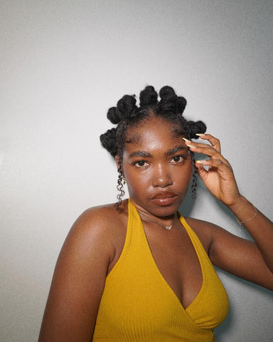 une fille avec une coiffure protectrice hivernale en bantu knots