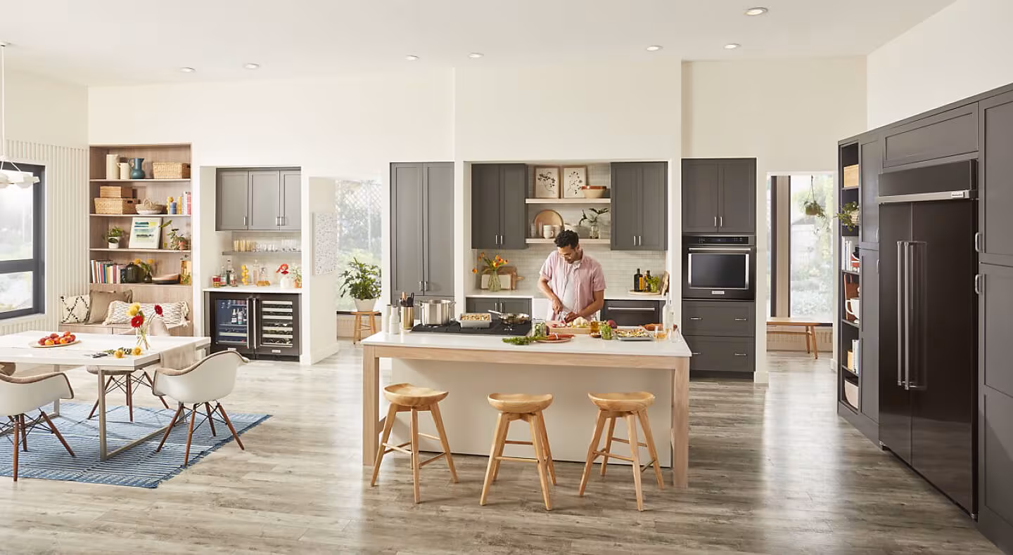 Person chopping produce on an island in modern kitchen Person chopping produce on an island in modern kitchen